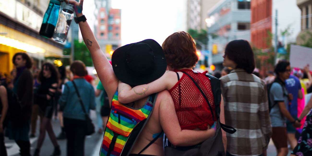 Two people with hands around each other shoulders