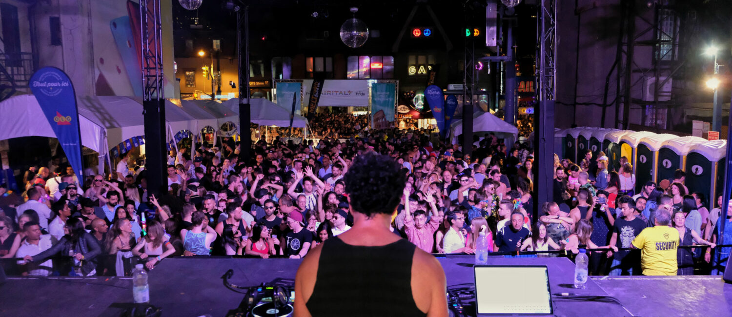 A DJ playing in front of a crowd on stage