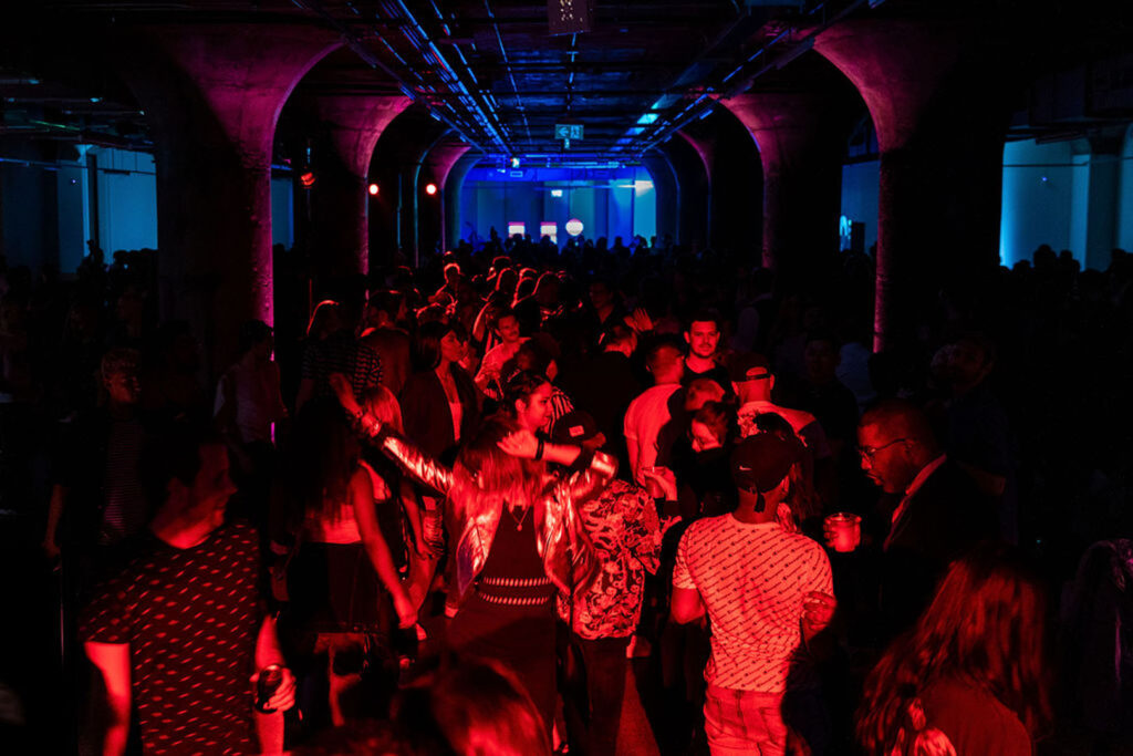 A crowd dancing in a underground club