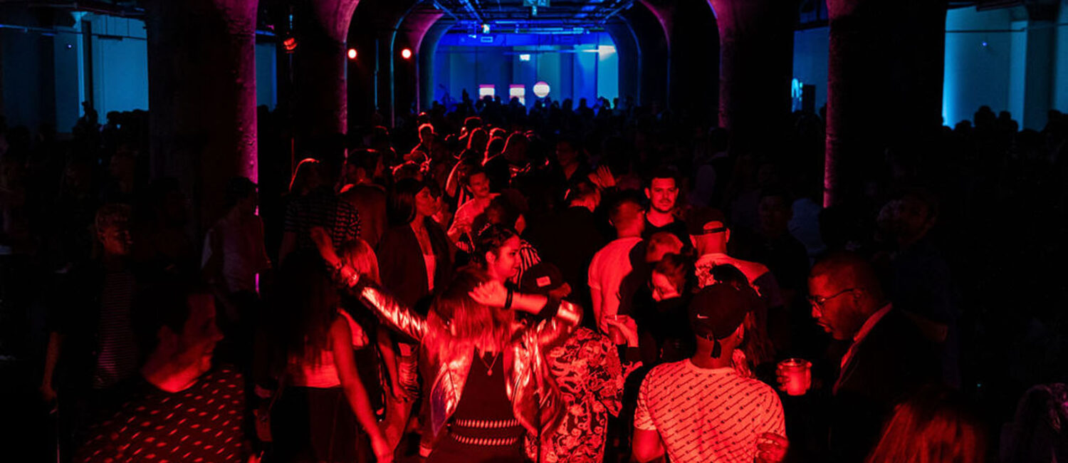 A crowd dancing in a underground club