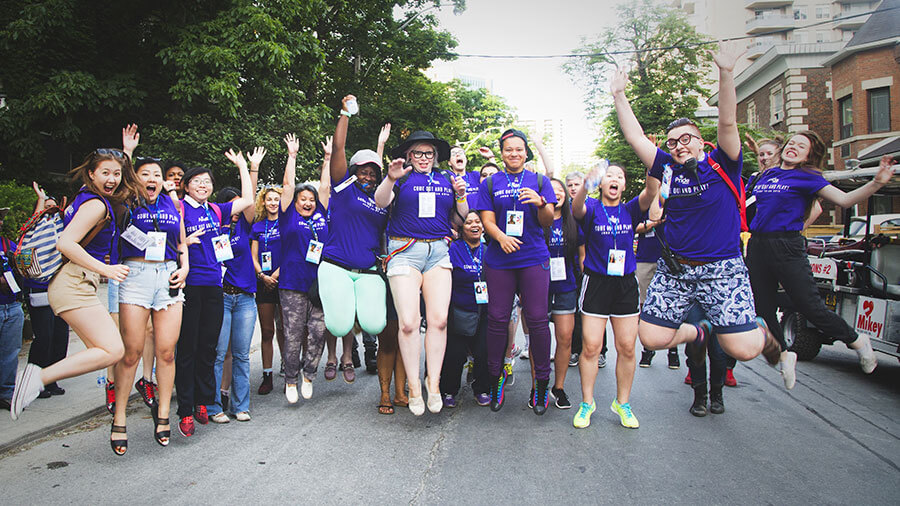 A group of volunteers jumping together in the middle of the street.