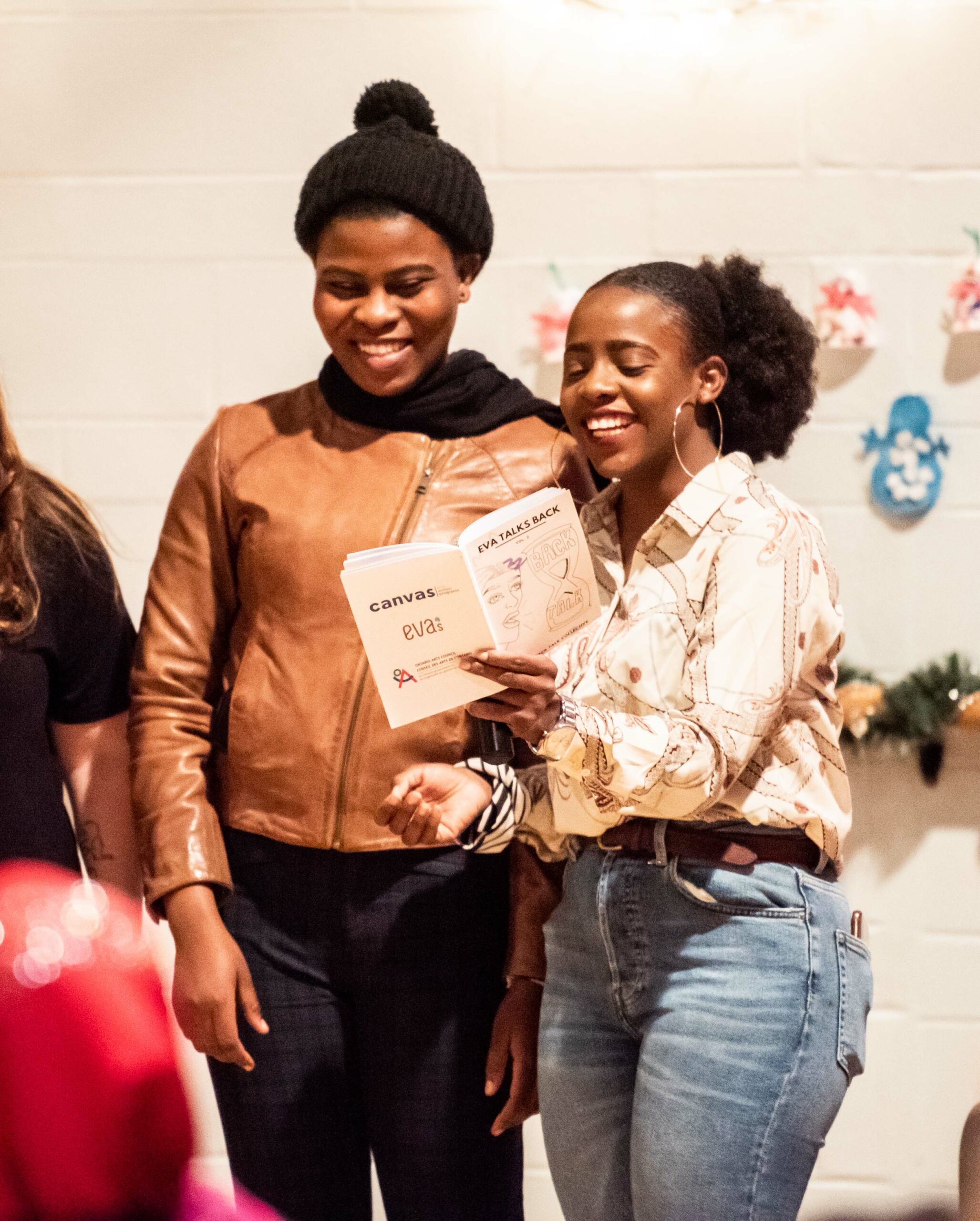 Two people holding a book