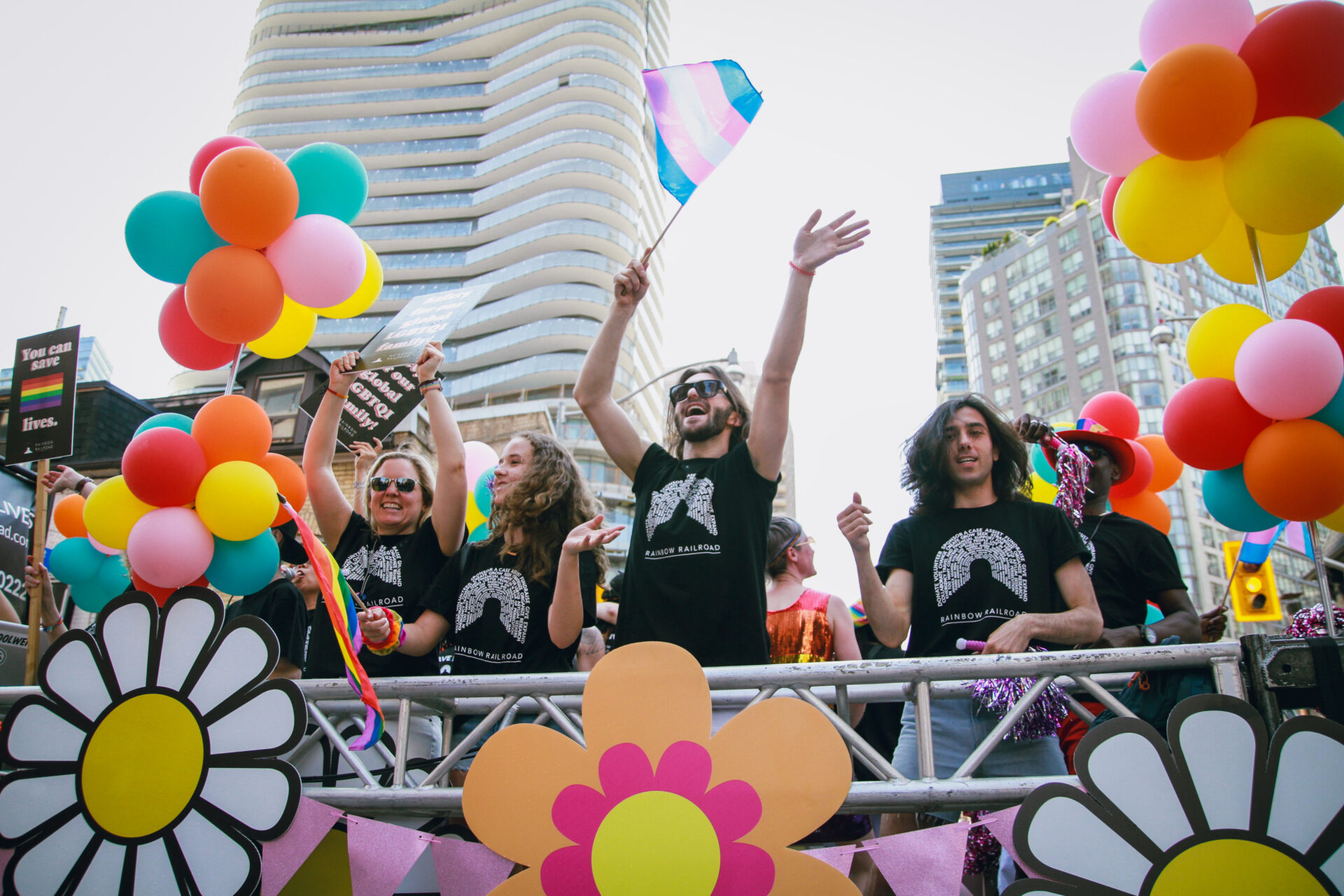Members of the Rainbow Railroad on a float waving and cheering