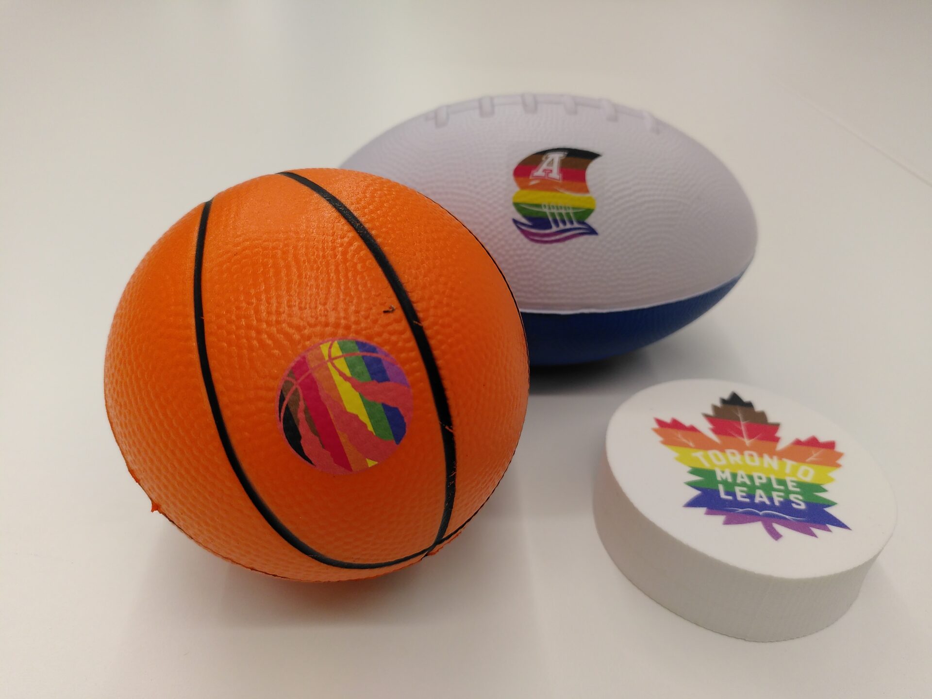 A MLSE Themed tiny basketball, football and puck