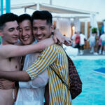 three people hugging each in front of a pool